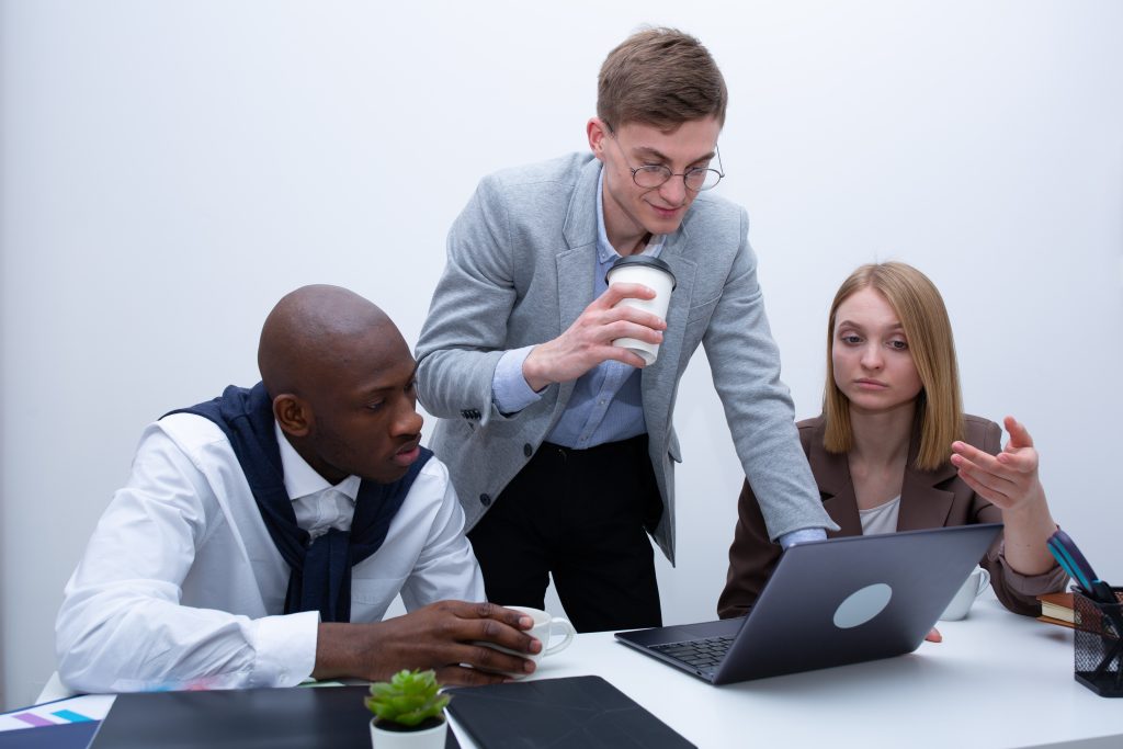 Three people in front of a laptop